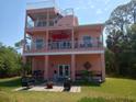 Multi-story home featuring balconies, patio, outdoor seating, and a private backyard oasis at 6926 Mccray Dr, Hudson, FL 34667