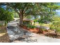 A large shade tree drapes across the driveway, with a boat parked in front of the 2-car garage at 8309 Pebble St, Spring Hill, FL 34608