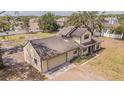 An aerial view shows a charming two-story home with an attached garage and well-maintained landscaping at 8908 Hixon Rd, Tampa, FL 33626