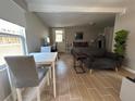 Cozy living area features wood-look tile floors, a dining table, a sofa, and a desk space at 943 7Th N St, St Petersburg, FL 33701