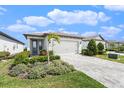 Charming single-story home featuring a well-manicured lawn and a brick-paved driveway at 10418 Spring Tide Way, Parrish, FL 34219