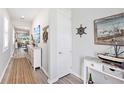 Bright hallway featuring coastal decor leading into an open-concept living space at 10418 Spring Tide Way, Parrish, FL 34219
