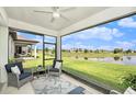 Relaxing screened lanai with comfortable seating and a tranquil view of the water and lush landscaping at 10418 Spring Tide Way, Parrish, FL 34219