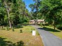 A long driveway leads up to a single-story home nestled among mature trees and lush landscaping at 11120 Lu Wista Ln, Brooksville, FL 34601