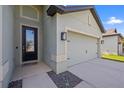 Inviting home featuring a traditional front door, a two-car garage, and manicured landscaping at 11831 Thicket Wood Dr, Riverview, FL 33579