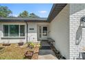Welcoming front entrance with a charming white door, window, and planters enhancing the home's curb appeal at 12493 Fish Cove Dr, Spring Hill, FL 34609