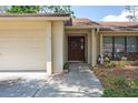 Welcoming entryway with an attractive front door and attached garage at 12606 Rain Forest St, Temple Terrace, FL 33617