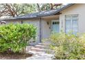 Welcoming front porch with a quaint blue door and decorative landscaping at 1310 Hilton Pl, Tampa, FL 33604