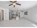 An open-concept layout integrates a kitchen island with seating, all highlighted by sleek marble flooring at 1341 Sandy Ln, Clearwater, FL 33755