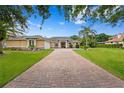 Beautiful exterior elevation showcasing a brick driveway, manicured lawn, and inviting facade at 19815 Sea Rider Way, Lutz, FL 33559