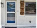 Inviting front entrance featuring a screen door, stylish wood shutters, and a decorative heart wreath at 2004 Yale Ave, Dunedin, FL 34698