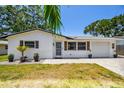 Lovely single-story home boasts a well-kept lawn and paved driveway, accentuated by decorative shutters and potted plants at 2004 Yale Ave, Dunedin, FL 34698