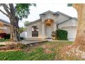 Inviting home with an arched entry and a lush front yard with mature trees at 24839 Wild Frontier Dr, Land O Lakes, FL 34639