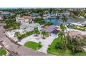 Aerial view of a waterfront property with lush landscaping, multiple pools, and neighboring canal homes at 300 10Th Ave, Indian Rocks Beach, FL 33785