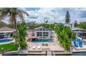 Backyard oasis featuring a private pool, travertine deck, lush greenery, and access to a canal at 300 10Th Ave, Indian Rocks Beach, FL 33785