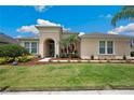 Inviting facade featuring manicured lawn, mulch beds and attractive landscaping at 3227 Watermark Dr, Wesley Chapel, FL 33544