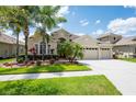 Charming single-story home with well-manicured lawn and landscaping, including mature trees and colorful flowerbeds at 3300 Stonegate Falls Dr, Land O Lakes, FL 34638