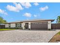 Lovely one-story home featuring a manicured lawn, brick driveway, and attached garage at 4331 13Th Ne Way, St Petersburg, FL 33703