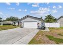 Well-kept single-story home with stone accents, white fenced yard, and an attached two-car garage at 507 Hammock Dr, Palm Harbor, FL 34683