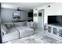 Comfortable living room with sectional sofa, modern TV console, and open dining area, perfect for relaxing at 5225 Coquina Key Se Dr # B, St Petersburg, FL 33705
