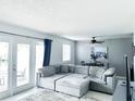 Light-filled living room featuring a cozy sectional sofa, neutral tones, and access to an outdoor patio at 5225 Coquina Key Se Dr # B, St Petersburg, FL 33705