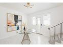 Bright foyer features tiled floor, modern light fixture, art and glass-topped table at 53 Albemarle Ave, Tampa, FL 33606
