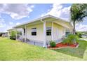 Exterior view of charming home featuring a covered porch and manicured landscaping at 5721 Apache St, Zephyrhills, FL 33542