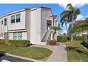 Two-story condo with a red tile roof, lush landscaping, and well-maintained sidewalk leading to the entrance at 6085 Bahia Del Mar Blvd # 106, St Petersburg, FL 33715