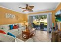 Bright living room with tile floors, a ceiling fan, and sliding glass doors opening to a patio at 6085 Bahia Del Mar Blvd # 106, St Petersburg, FL 33715