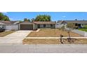 Well-kept single-story home featuring an attached garage and mature landscaping at 6812 Fountain Ave, Tampa, FL 33634