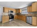 Bright kitchen featuring wood cabinets, stainless steel appliances and tiled backsplash at 6812 Fountain Ave, Tampa, FL 33634
