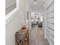 Bright hallway with wood floors, white trim, staircase, decorative window, and entry to living area at 785 52Nd N Ave, St Petersburg, FL 33703