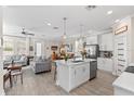 Open concept kitchen with center island, stainless steel appliances, modern lighting, and easy access to living area at 785 52Nd N Ave, St Petersburg, FL 33703