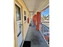 Apartment hallway featuring exterior doors, vibrant red support beams, and secure entrance at 8565 W Gulf Blvd # 21S, St Petersburg, FL 33706