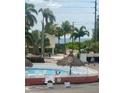Community pool area surrounded by lush palm trees near the beach at 8565 W Gulf Blvd # 21S, St Petersburg, FL 33706