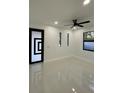 Well-lit room featuring sleek tile flooring, modern ceiling fan, and contemporary door design at 907 E Okaloosa Ave, Tampa, FL 33604