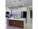 Bright kitchen showcasing white cabinets, a stylish island with a wooden accent, and modern pendant lighting at 907 E Okaloosa Ave, Tampa, FL 33604