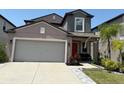 Charming two-story home with manicured lawn, palm tree and seating area at 9616 Lemon Drop Loop, Sun City Center, FL 33573