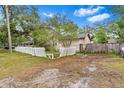 Charming tan home featuring a quaint entrance, complemented by a classic white picket fence and yard at 10803 N Florence Ave, Tampa, FL 33612