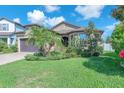 Charming single Gathering home featuring landscaping, and a well-manicured lawn under a blue sky at 11606 Kilkenny Coral Dr, Riverview, FL 33579
