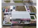 Aerial view of pink house with backyard, patio and pool, surrounded by a fence with multiple cars in driveway at 12425 Ridge Rd, Largo, FL 33778