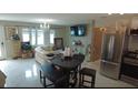 Open living area with white floors, cream colored couch, stainless steel appliances and dining area seating four at 12425 Ridge Rd, Largo, FL 33778