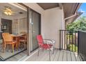 Relaxing balcony area with a red chair and adjacent dining area, perfect for outdoor enjoyment at 12804 Wedgewood Way # C, Hudson, FL 34667