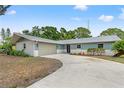 Well-maintained single-story home features a spacious driveway leading to an attached two-car garage at 13211 111Th Ln, Largo, FL 33778