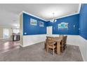 Dining room with blue accent wall and wood table with 4 chairs at 14233 Edinburgh Moor Dr, Wimauma, FL 33598