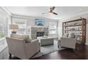 Comfortable living room features a stone fireplace, large windows, and sleek dark hardwood floors at 157 9Th N Ave, St Petersburg, FL 33701