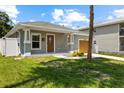 Inviting single-story home with a beautiful lawn and a charming front entrance at 2906 E Columbus Dr, Tampa, FL 33605