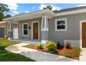 Inviting covered porch with decorative columns and a beautifully landscaped garden at 2906 E Columbus Dr, Tampa, FL 33605