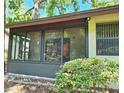 Enclosed and screened patio with view of the lush backyard at 2910 Star Apple Ct, Palm Harbor, FL 34684