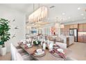 Elegant dining area featuring a set table and open view to the stylish and comfortable living area at 32249 Tribeca Ave, Wesley Chapel, FL 33543